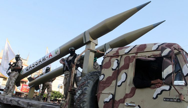 عناصر من "كتائب القسام" يعرضون صواريخ محلية الصنع خلال عرض عسكري