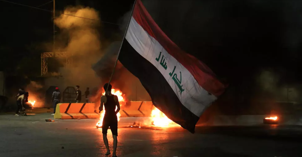 متظاهرون عراقيون يحرقون إطارات أمام مقر محافظة كربلاء وسط مدينة كربلاء، في وقت مبكر من 9 أيار/مايو 2021، عقب اغتيال ناشط مناهض للحكومة محمد صواف