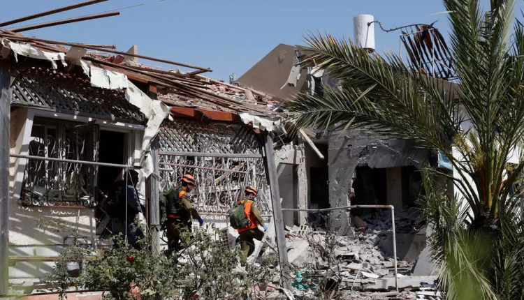 خبراء ألغام إسرائيليون يسيرون في منزل مدمر في مدينة عسقلان جنوب إسرائيل في 11 مايو 2021