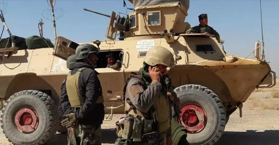 عناصر أمن أفغان قرب مركبة مدرعة خلال المعارك على أطراف "لشكر قاه" في هلمند. 5 أيار/مايو 2021
