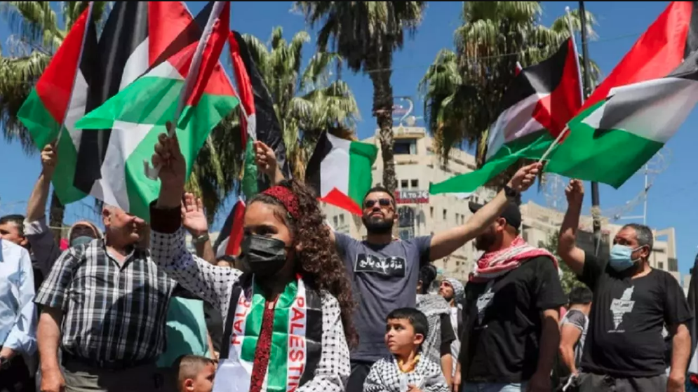 متظاهرون فلسطينيون يحملون العلم الفلسطيني وسط مدينة رام الله في الضفة الغربية المحتلة يتضامنون مع قطاع غزة