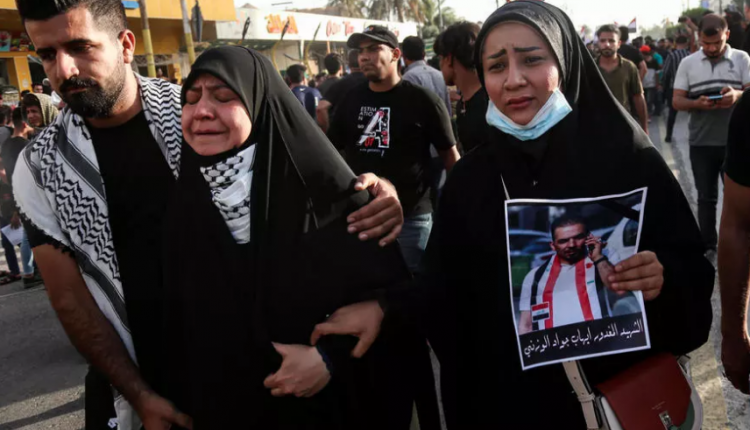 مشيعون خلال جنازة الناشط العراقي المناهض للحكومة إيهاب الوزني في وسط مدينة كربلاء