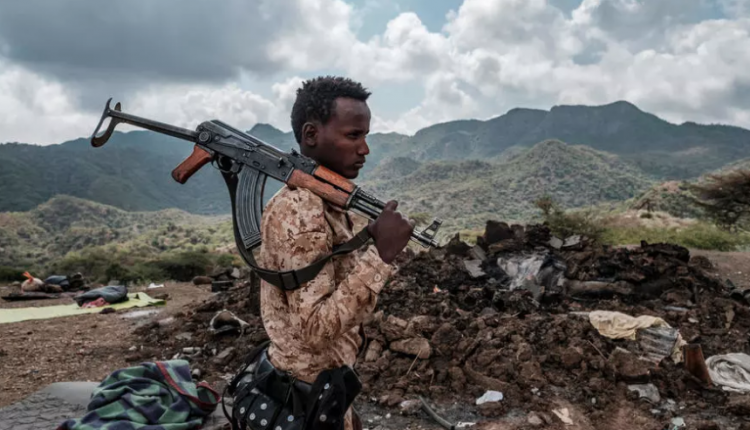 أحد أفراد القوات الخاصة في عفار أمام أنقاض منزل في ضواحي قرية بيسوبر بمنطقة تيغراي في إثيوبيا