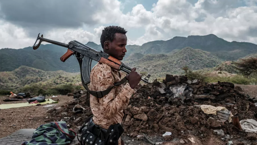 أحد أفراد القوات الخاصة في عفار أمام أنقاض منزل في ضواحي قرية بيسوبر بمنطقة تيغراي في إثيوبيا