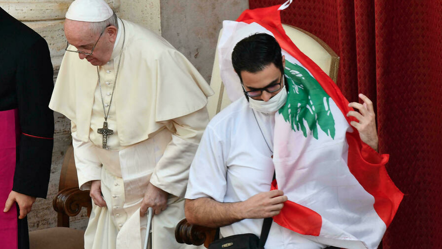 قس لبناني يحمل علم بلاده بعدما صلى مع البابا فرنسيس في الفاتيكان
