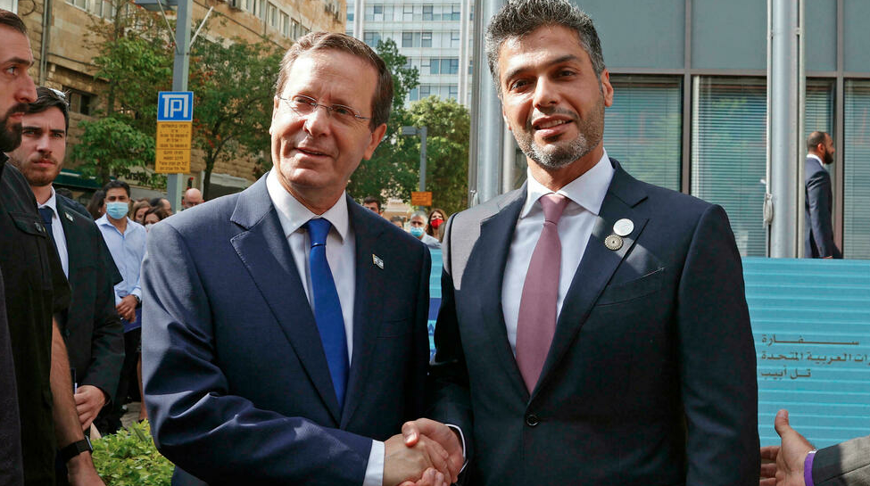 الرئيس الإسرائيلي إسحاق هرتسوغ (يسار) والسفير الإماراتي لدى إسرائيل محمد آل خاجة يتصافحان خارج مقر السفارة الإماراتية في تل أبيب